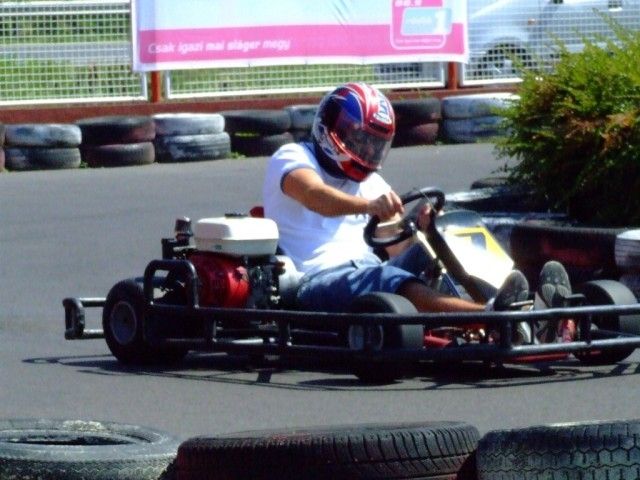 Fehér bukósisakos pilóta a gokartban